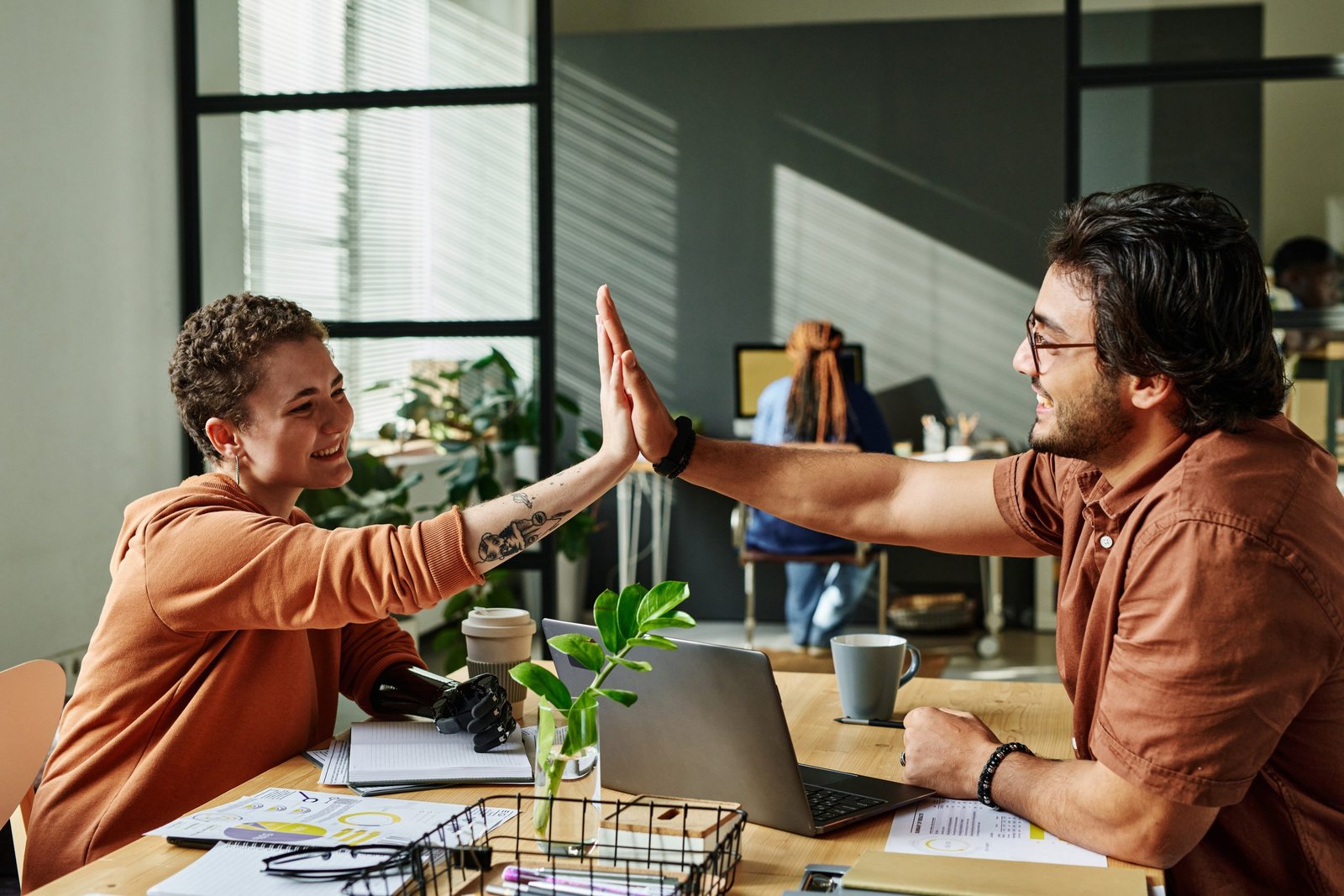 Two successful colleagues giving each other high five